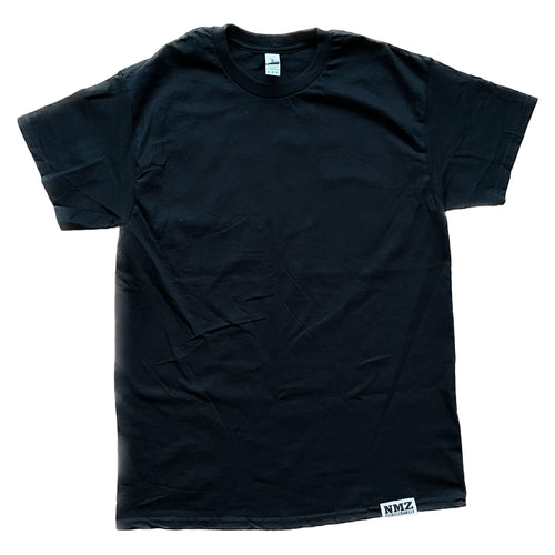 A plain black NMZ "Tagged" Shirt lies flat, featuring a small rectangular NMZ tag sewn at the bottom hem.